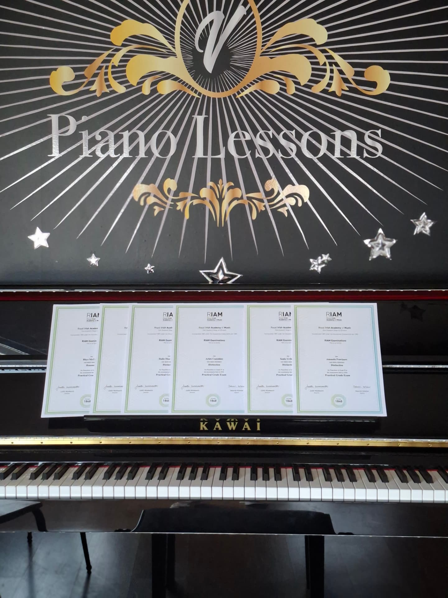 RIAM exam certificates displayed on the piano