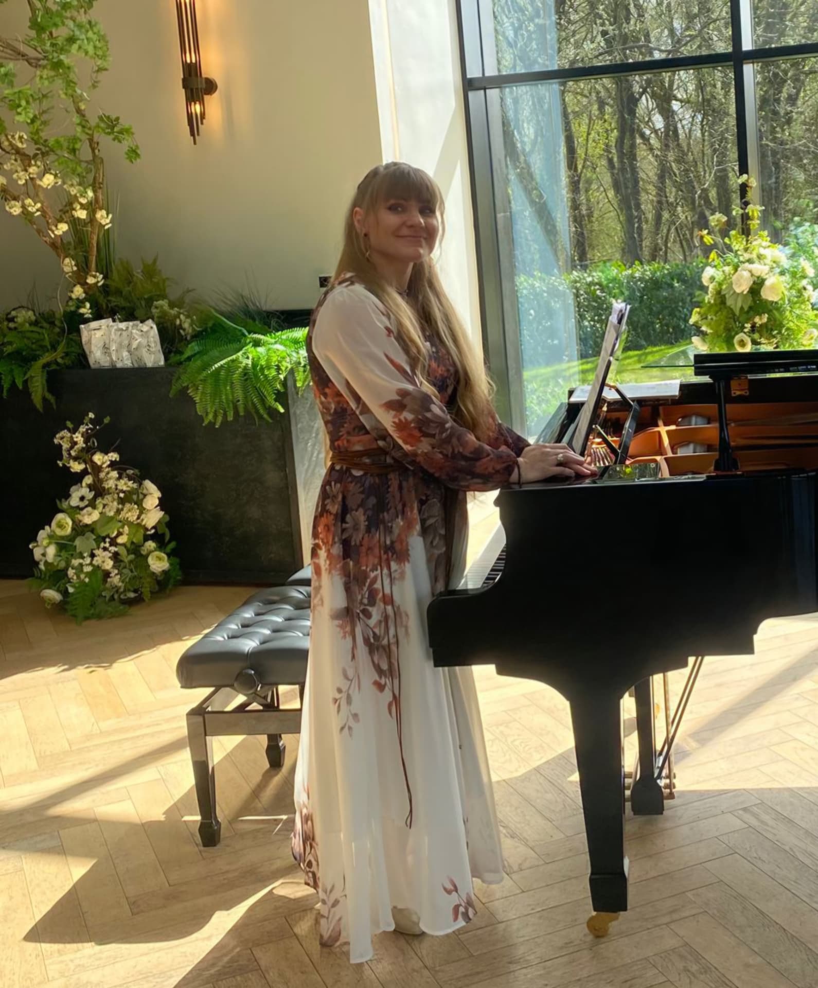 Vilma, piano teacher, standing at a grand piano